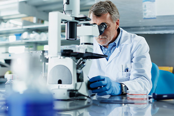 Person looking through microscope